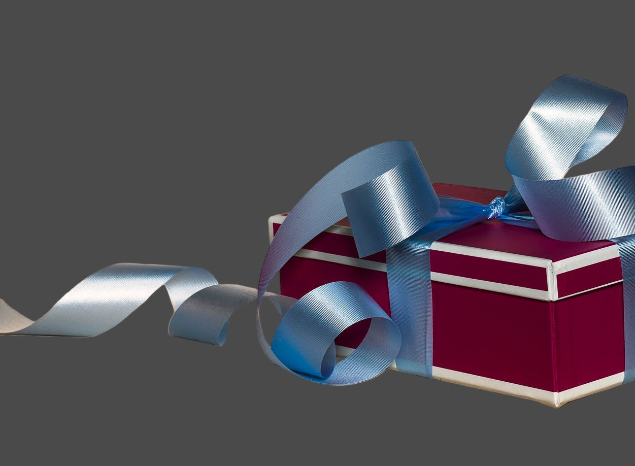 Red gift box with a silver ribbon on a wooden surface